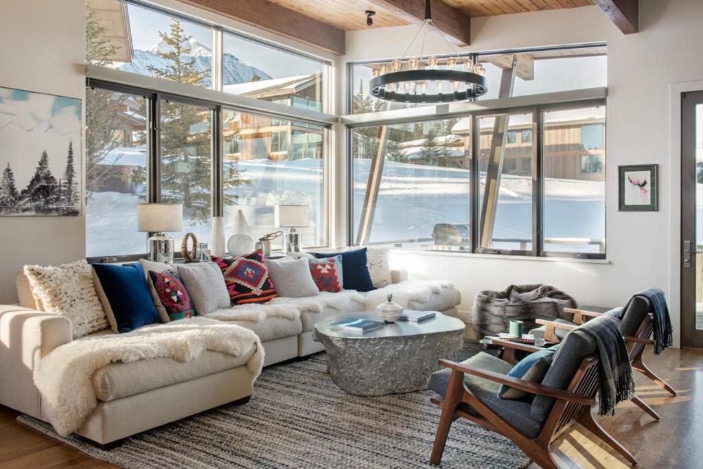 a living room with a couch and a large window at Tanager House in Big Sky
