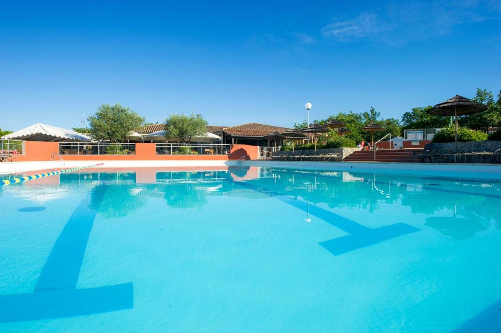 a large swimming pool with blue water at Hotel Domaine de Chaussy in Lagorce