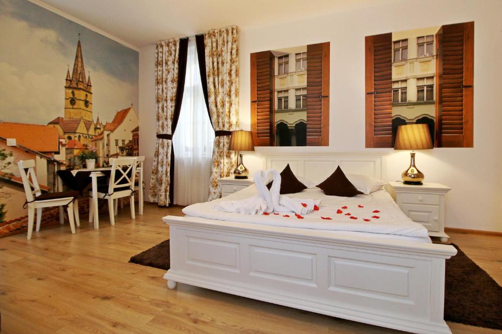 Un dormitorio con una cama blanca con flores. en Arhivelor Apartment en Sibiu