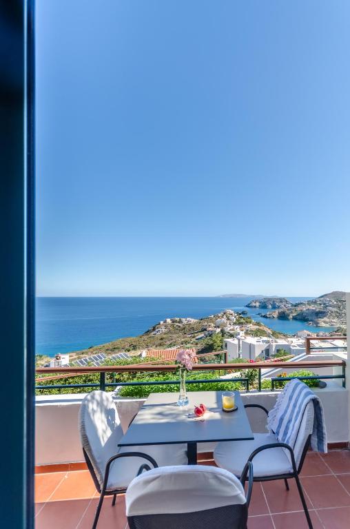 Ein Tisch und Stühle auf einem Balkon mit Blick auf das Meer in der Unterkunft Pela Mare Hotel in Agia Pelagia