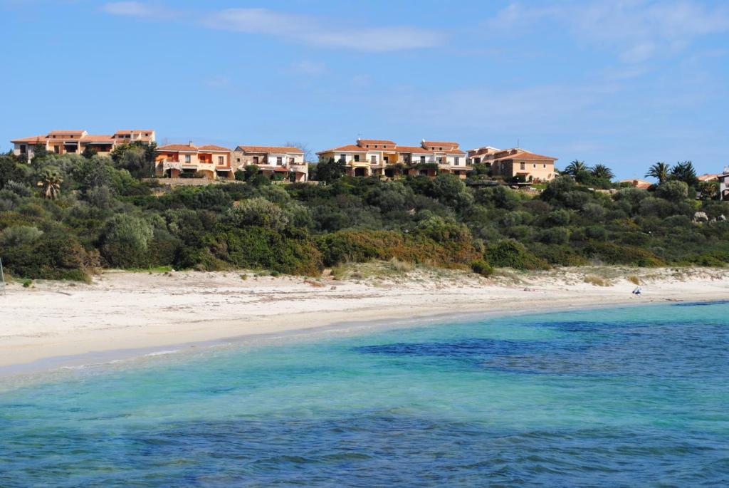 a view of a beach with houses on a hill at Appartamenti Spiaggia Bianca in Golfo Aranci