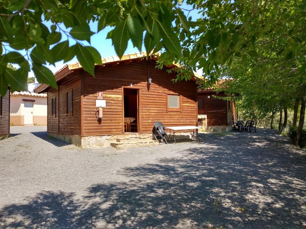 une cabane en rondins avec une véranda et un banc dans l'établissement Camping Casa Fausto Cerca de Dinopolis, à Formiche Alto