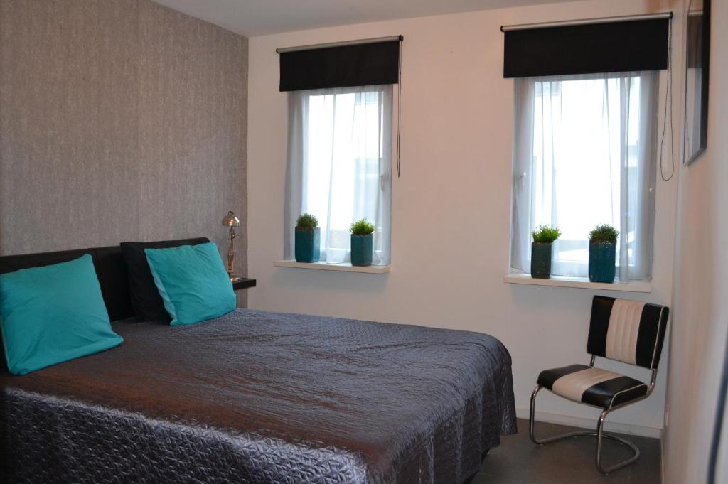 1 dormitorio con 1 cama, 2 ventanas y 1 silla en Bed & Breakfast ‘t Westergouwertje en Gouda