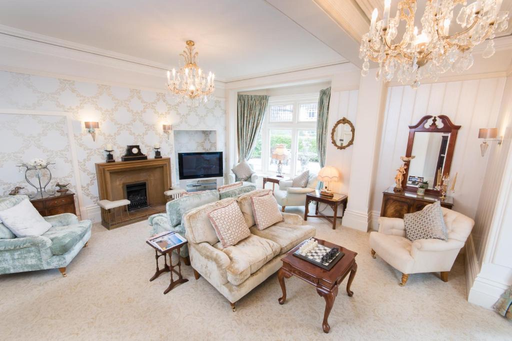 a living room filled with furniture and a chandelier at Grovefield Manor in Poole