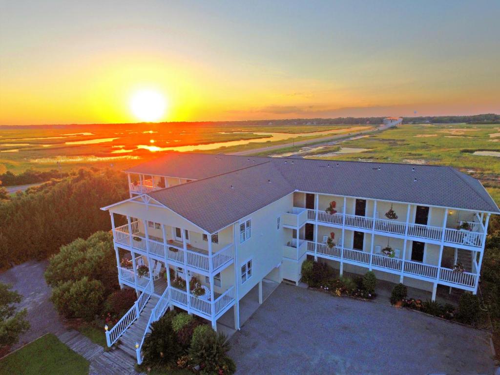 una vista aérea de una casa con la puesta de sol en el fondo en The Sunset Inn en Sunset Beach