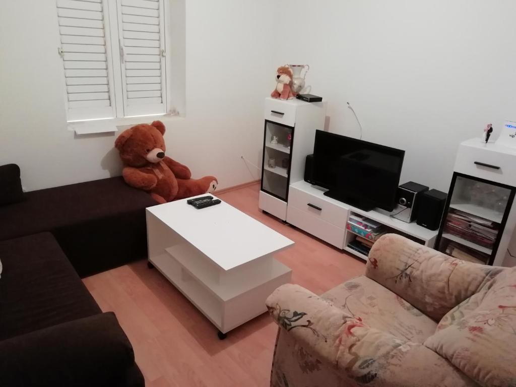 a living room with a teddy bear sitting on a couch at Apartman Radic in Ston