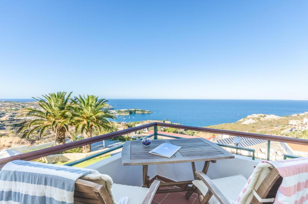 a dining room table with a balcony overlooking the ocean at Pela Mare Hotel in Agia Pelagia