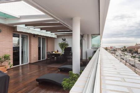 einen Balkon eines Gebäudes mit einem Tisch und Stühlen in der Unterkunft LUXURY PENTHOUSE near beach/Seaview in Valencia