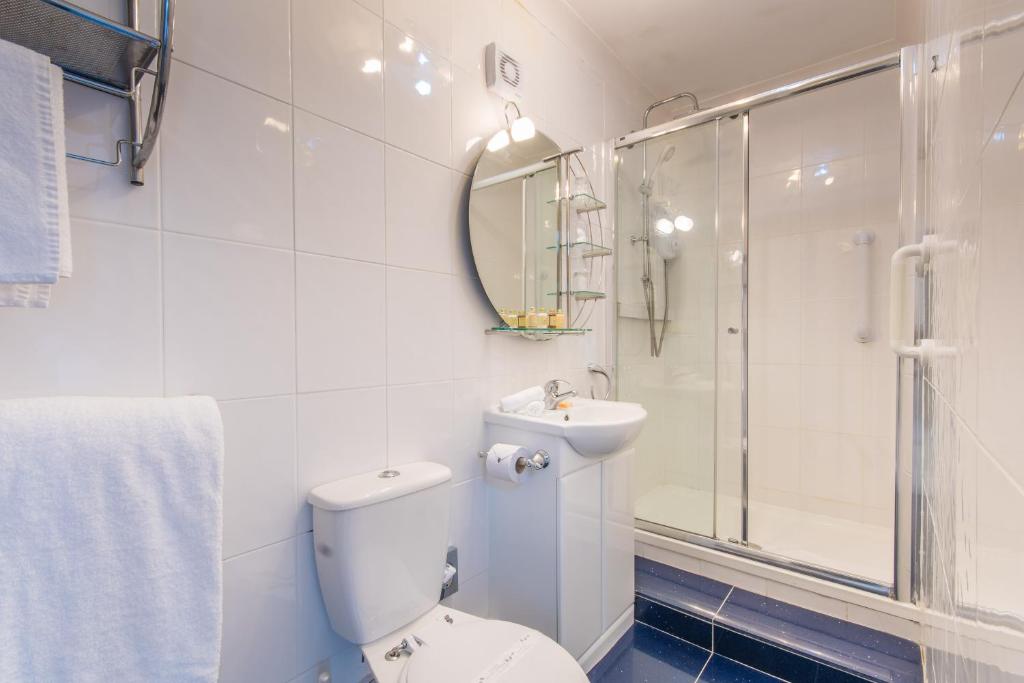 a bathroom with a toilet and a sink and a shower at Grovefield Manor in Poole