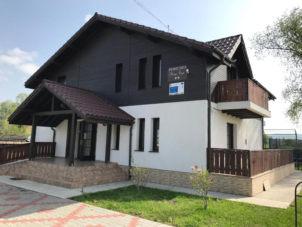 a black and white house with a porch at Pensiunea Dany - Crys in Zvoriştea