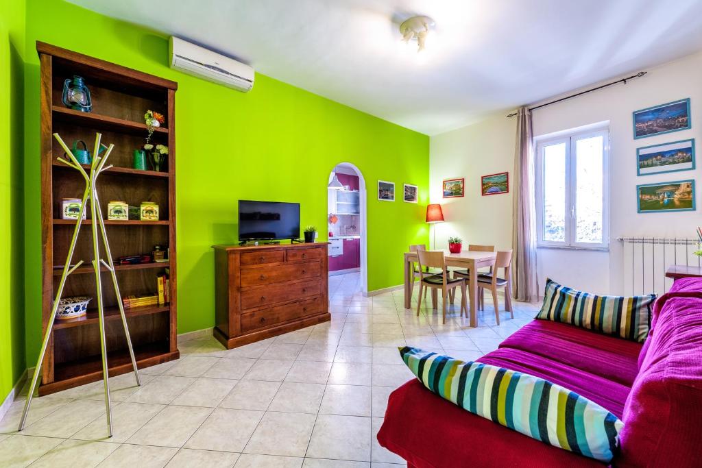 een woonkamer met groene muren en een rode bank bij Apartment Angelo Emo 69 in Rome