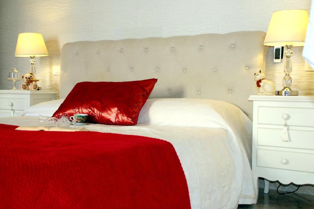 ポルト・チェザーレオにあるStella Marinaの白いベッドの上に赤い枕(赤い毛布付)