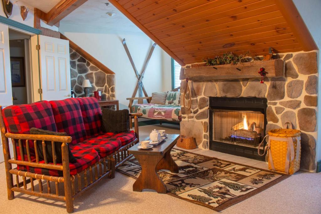 a living room with a stone fireplace and a chair at Inn at Herr Ridge in Gettysburg