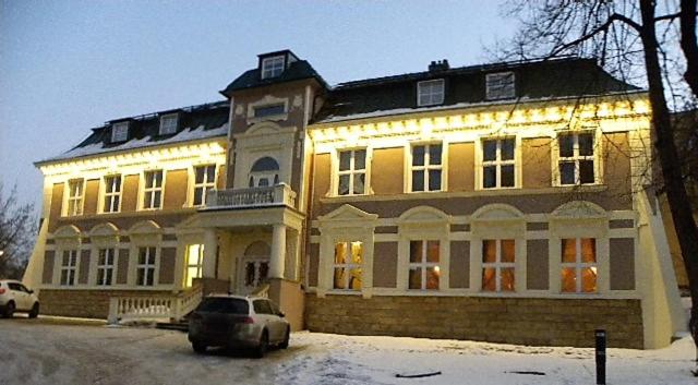 Pałac Dąbrowa في دونبروفا جورنيتشا: مبنى كبير فيه سيارة متوقفة أمامه