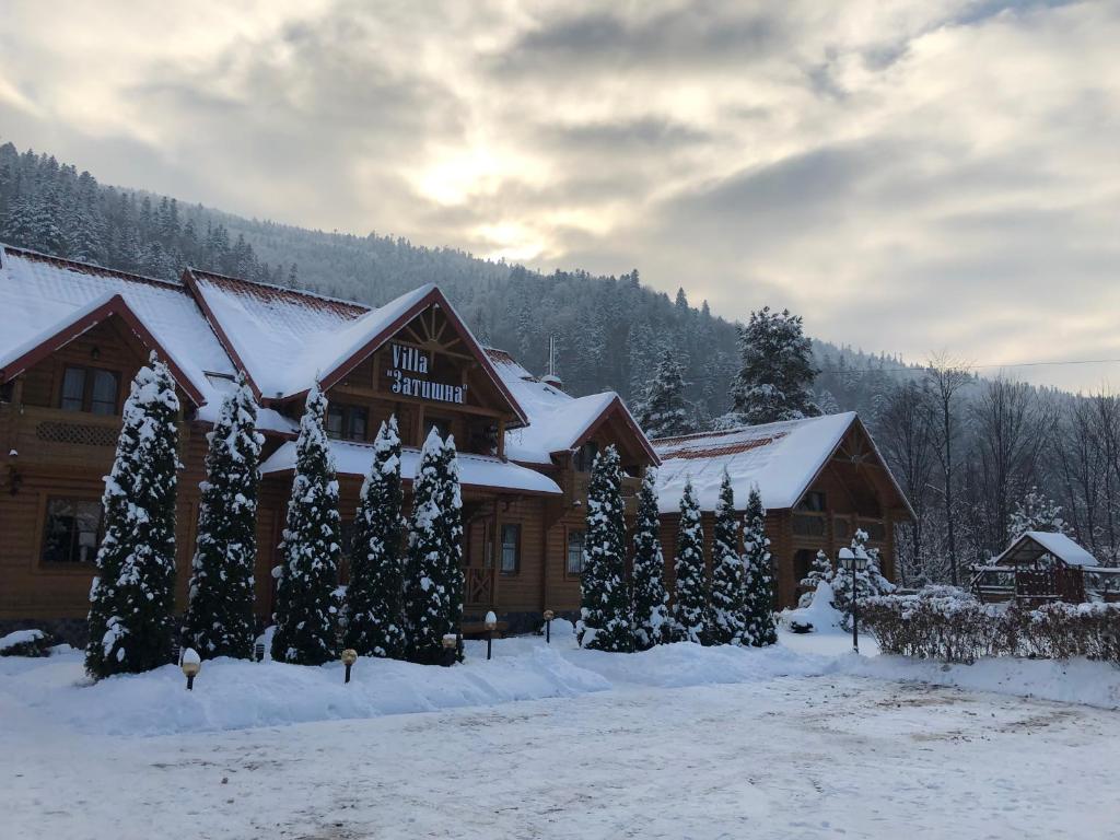a lodge in the snow with snow covered trees at Villa "Затишна" in Mykulychyn