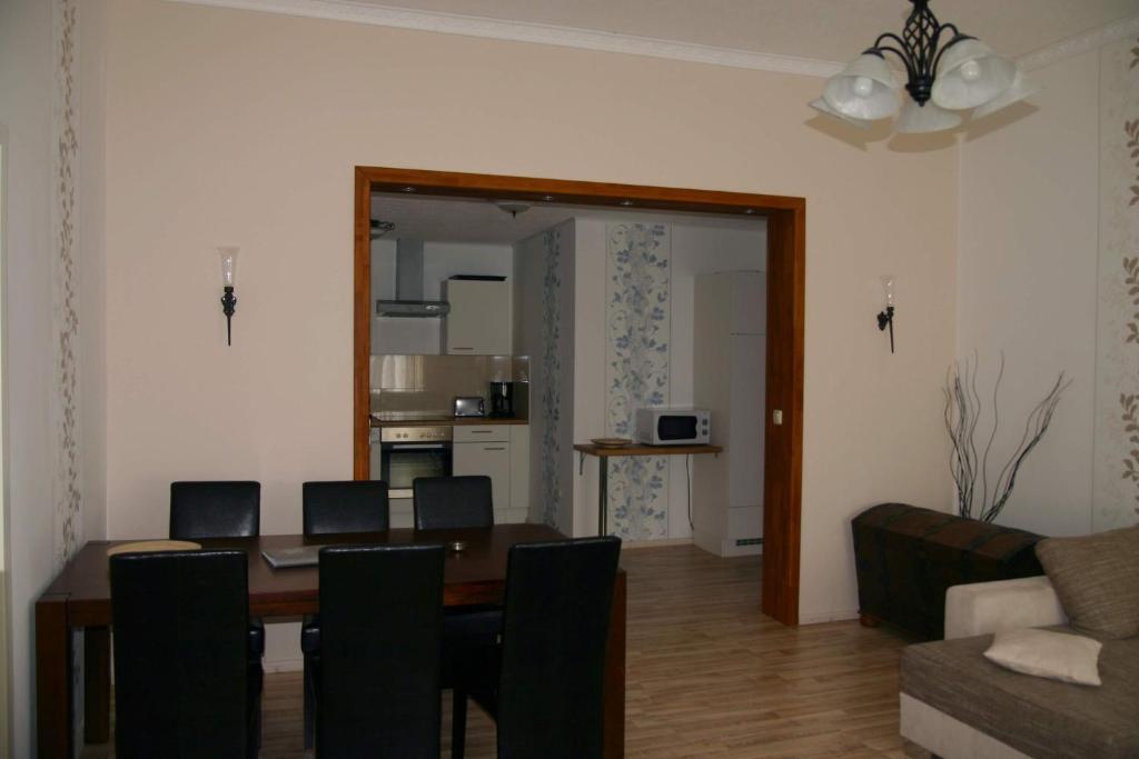 a dining room with a table and chairs and a living room at FeWo Vahls Mika in Elmenhorst