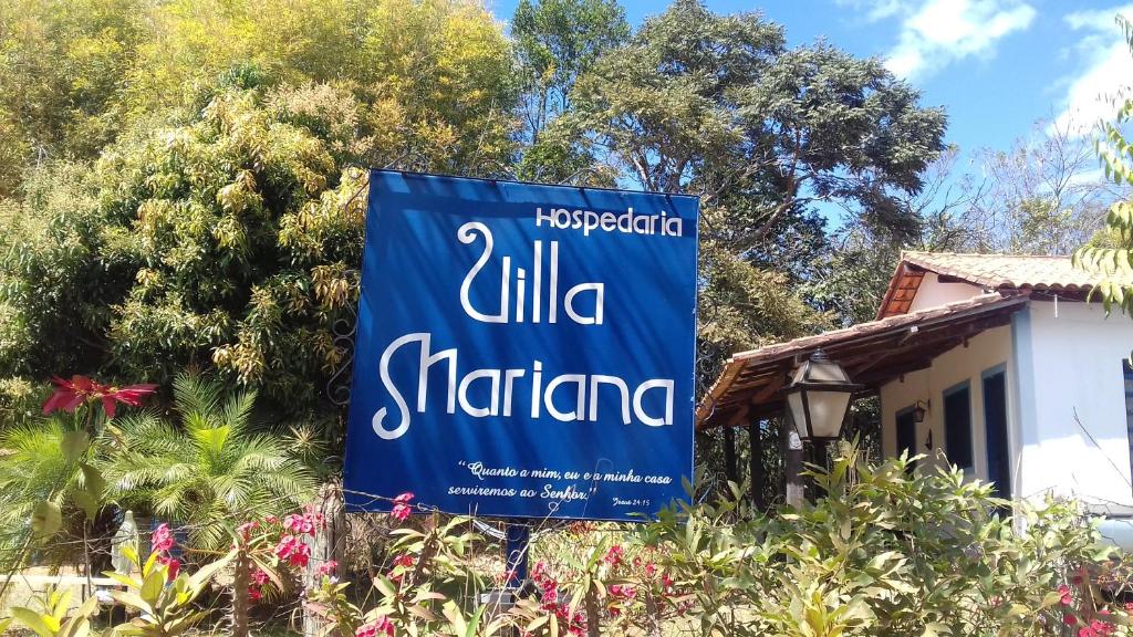una señal azul delante de una casa en Hospedaria Villa Mariana en Santo Antônio do Leite