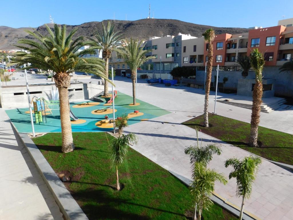 a playground with palm trees in a parking lot at LOLALAND in Morro del Jable