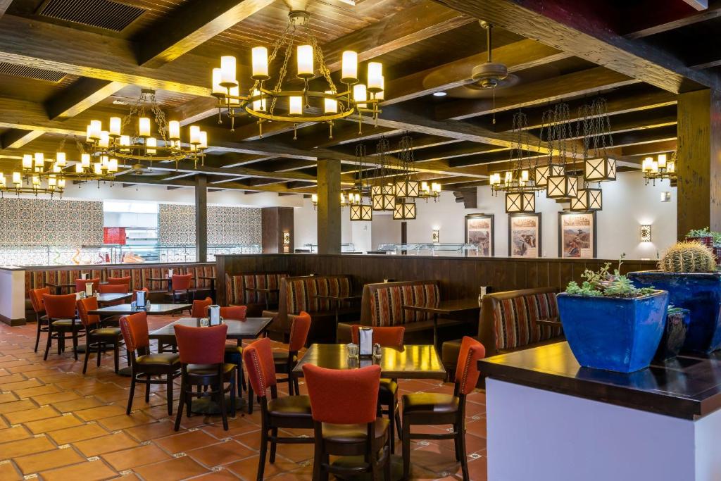 a dining room with tables and chairs and chandeliers at The Ranch At Death Valley in Indian Village