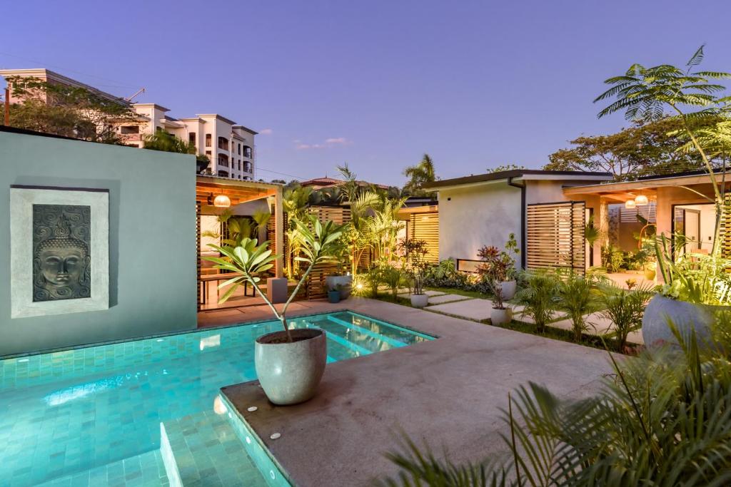 a home with a swimming pool and a house at Zen Garden Tamarindo - Adults Only in Tamarindo