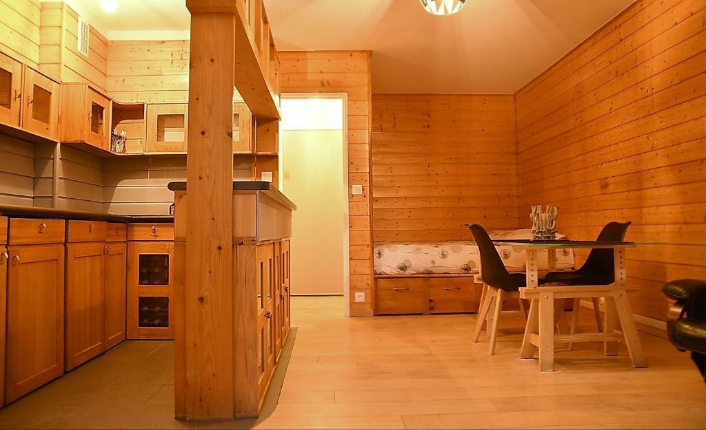 una cucina con tavolo e sedie in una stanza di F1 entier Cosy style CHALET Montgeron, Proche Paris a Montgeron