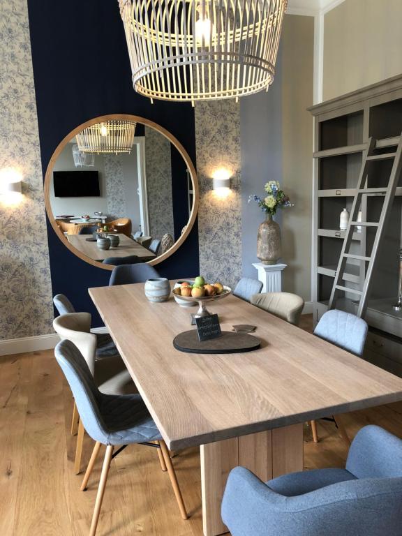 een eetkamer met een tafel en een spiegel bij Hotel Ahrbella in Bad Neuenahr-Ahrweiler