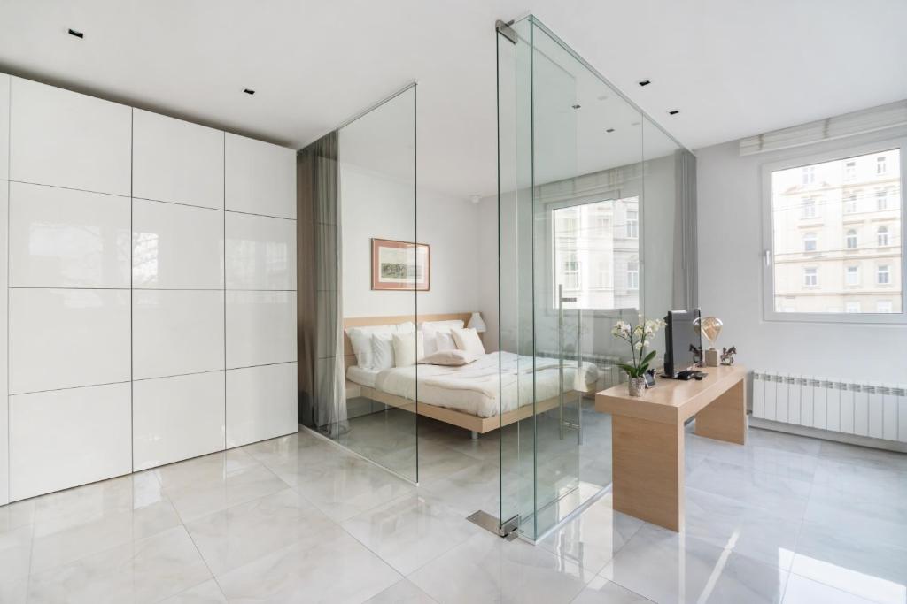 Habitación de cristal con cama y mesa en Elegant Cozy Apartment, en Viena