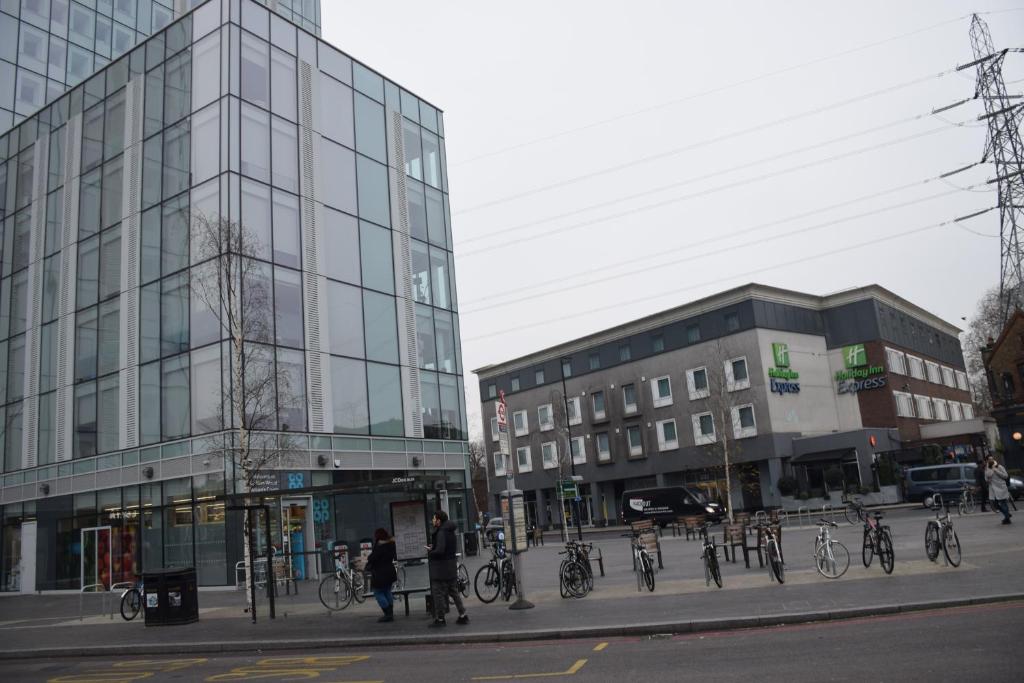 un groupe de vélos garés sur un trottoir à côté d'un bâtiment dans l'établissement 4 Bedroom Apartment & 2 Bedroom apartment, à Londres