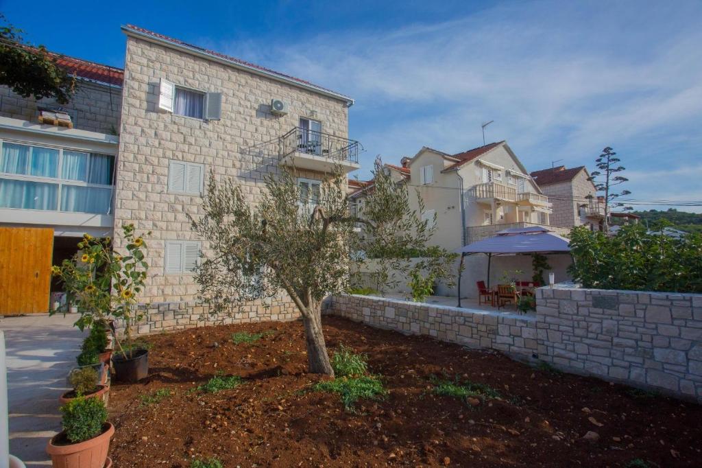 una casa con una pared de retención y un árbol en un patio en Apartments Mato - with parking, en Sutivan