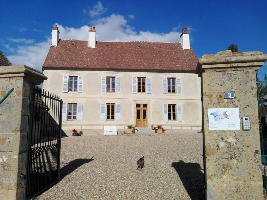 une grande maison blanche avec un portail en face de celle-ci dans l'établissement Chez Casimir, à Cercy-la-Tour