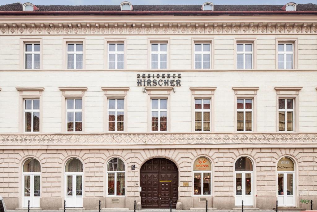 a large white building with a sign on it at Residence Hirscher in Braşov