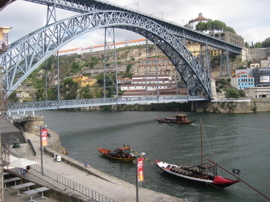 due barche in acqua sotto un ponte di Historic Oporto Apartment at oporto UNESCO area, in front of Porto Wine caves a Porto