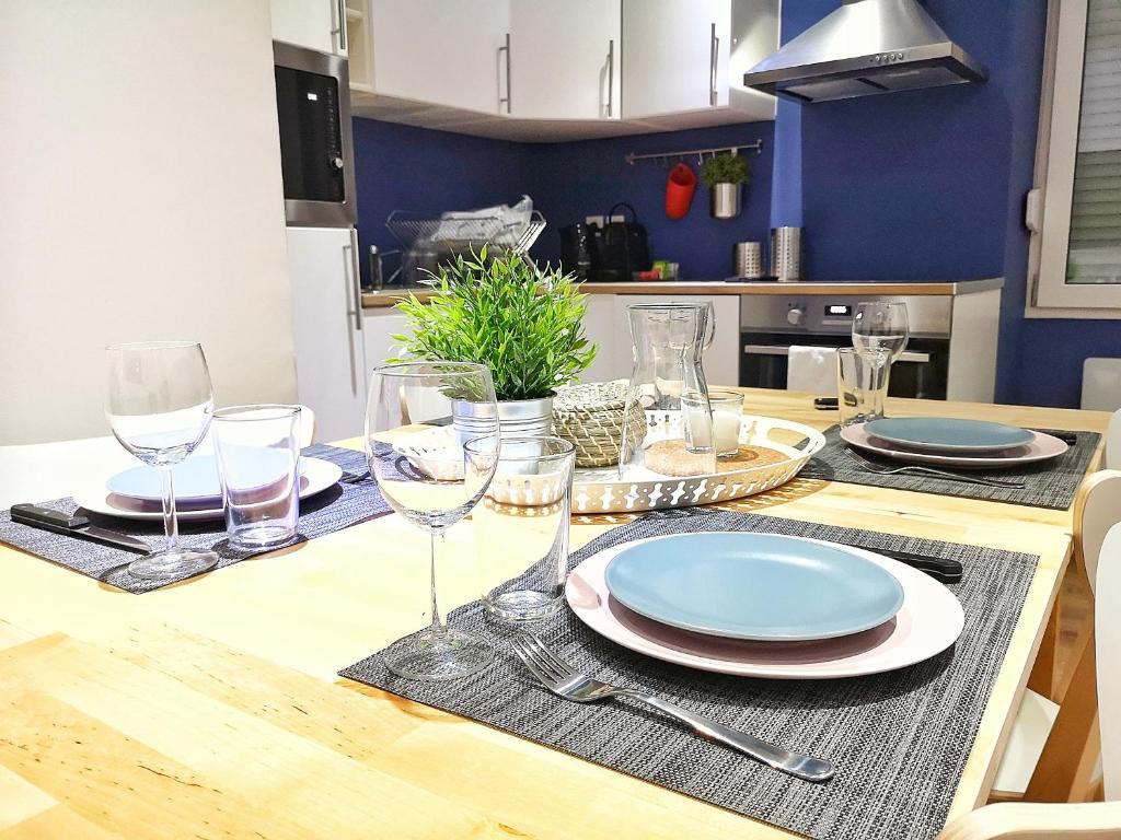une table avec des assiettes et des verres à vin dessus dans l'établissement Au p'tit Cordonnier, à Colmar