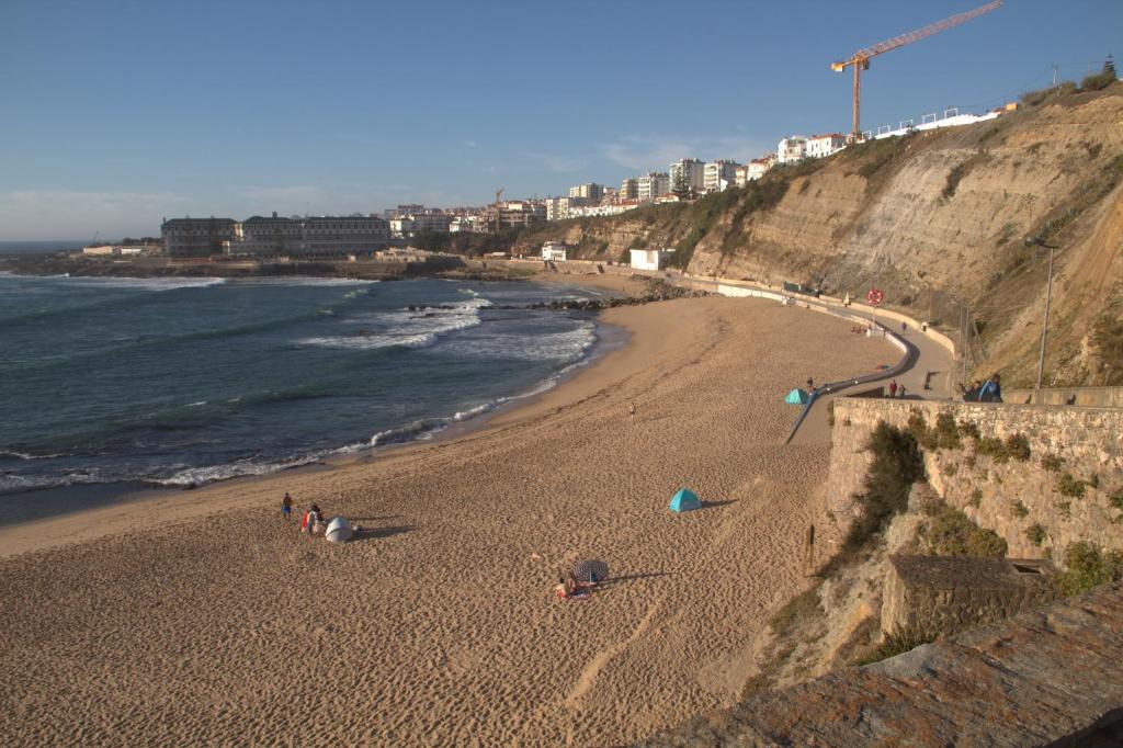 a group of people on a beach near the ocean at Ericeira Sunset Apartment in Ericeira