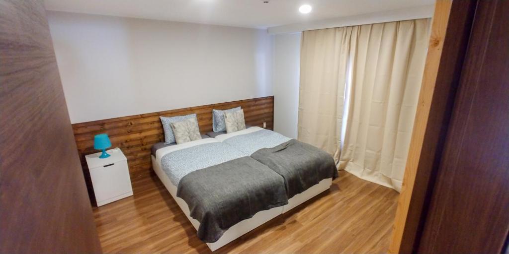 白馬的住宿－Hakuba Powder Cottage Crystal，一间卧室配有一张带木制床头板的床