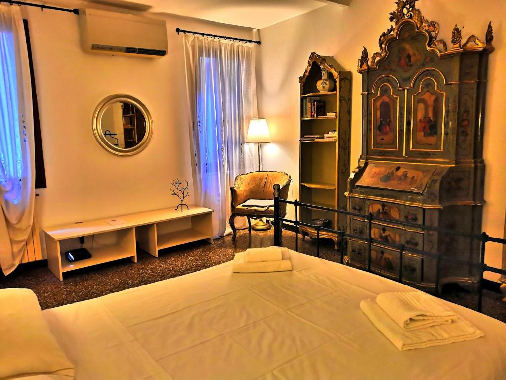 a bedroom with a large bed and a chair at APPARTAMENTO Ruga Giuffa in Venice