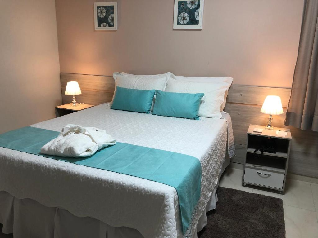 a bedroom with a bed with a teddy bear on it at Hotel San Remo in Jequié