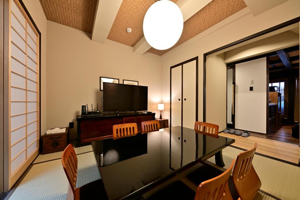a living room with a dining room table and a television at Luxury Machiya Takeya Nishijin in Kyoto