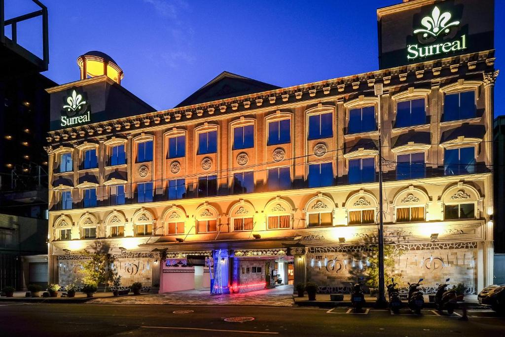 a lit up building with people standing in front of it at Surreal Motel in Xinzhuang