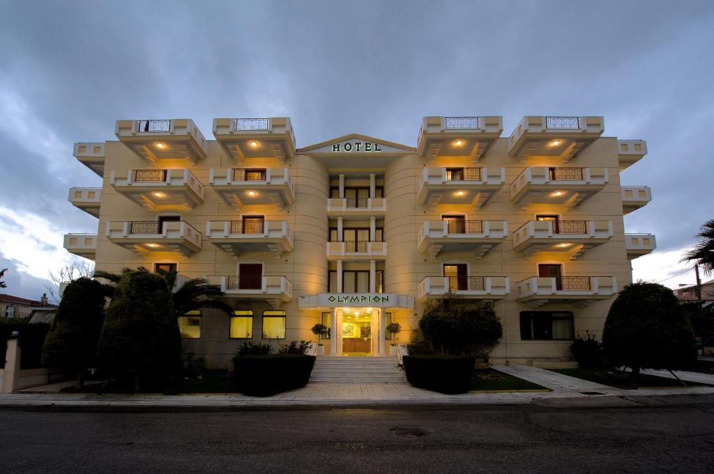 Un grand bâtiment blanc avec des escaliers y mène. dans l'établissement Olympion, à Athènes