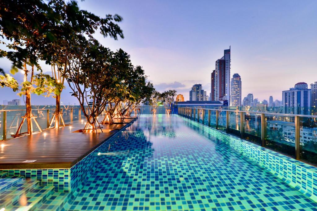 a swimming pool with a city skyline in the background at Civic Horizon Hotel & Residence in Bangkok
