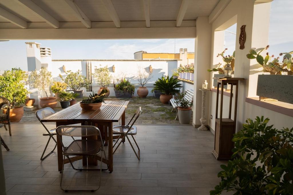 un patio al aire libre con mesa de madera y sillas en MaMà Suite, en Lecce