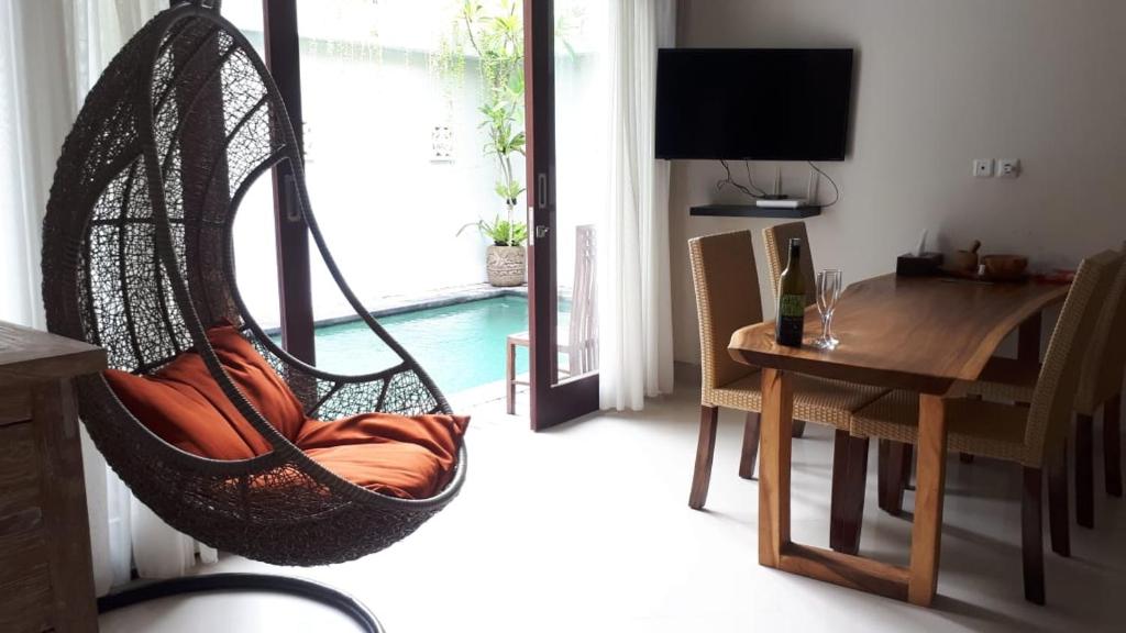una hamaca colgante en una sala de estar con mesa en Villa Reisya, en Nusa Dua