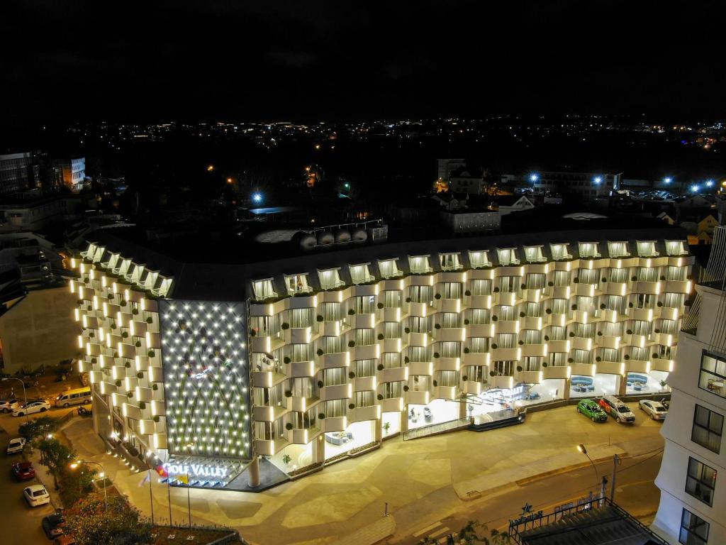 un gran edificio con luces encendidas por la noche en Golf Valley Hotel, en Da Lat