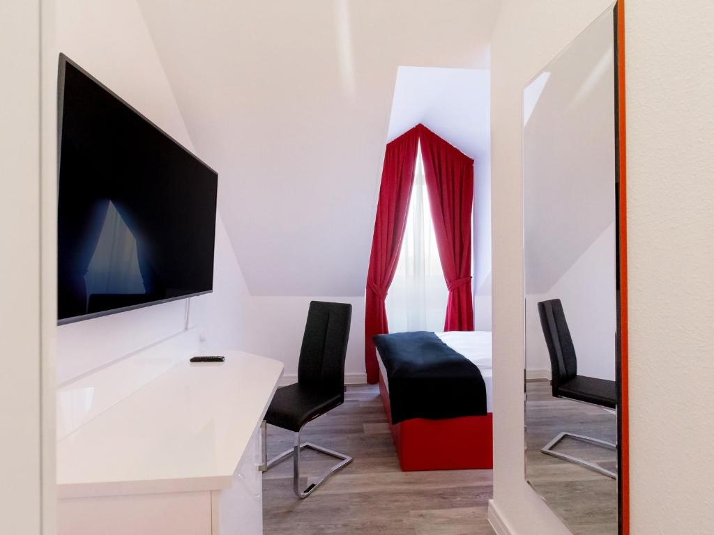 TV a/nebo společenská místnost v ubytování DORMERO Hotel München-Kirchheim Messe
