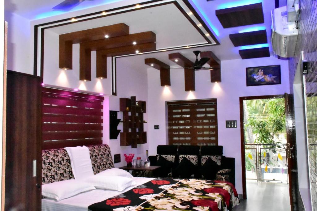 a living room with purple walls and a bed and a ceiling at Mary Land Homestay in Trivandrum