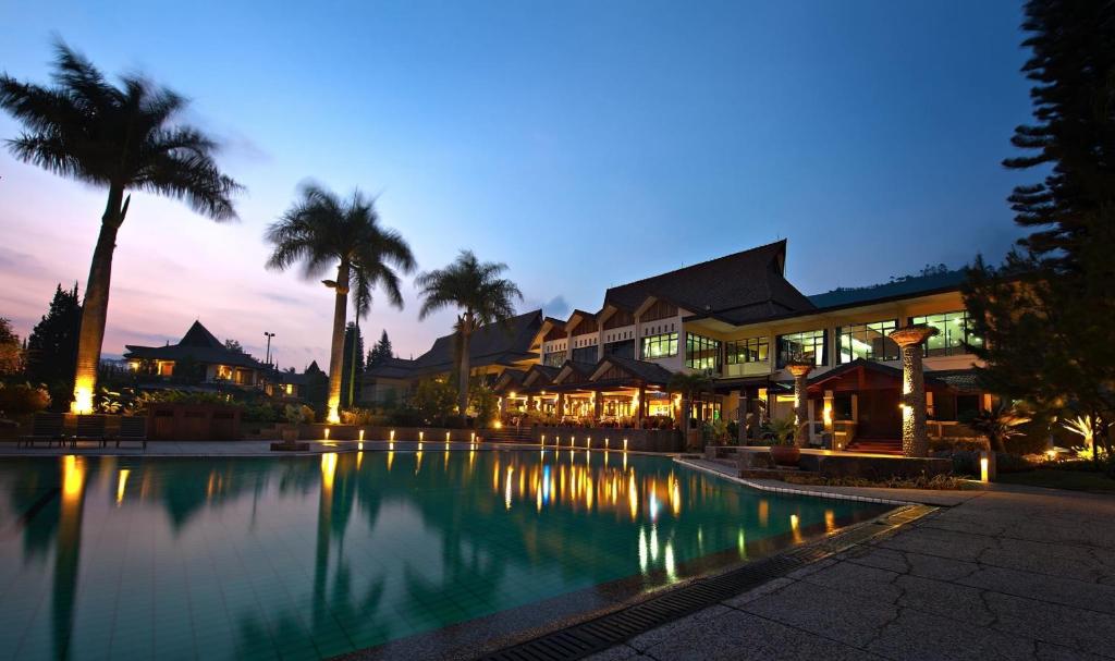 a resort with a large swimming pool at night at Puteri Gunung Hotel in Lembang
