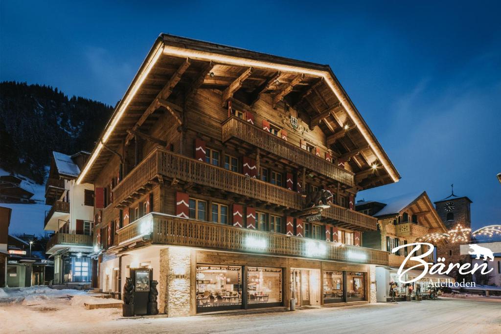 un grande edificio con un negozio di fronte nella neve di Hotel Bären ad Adelboden