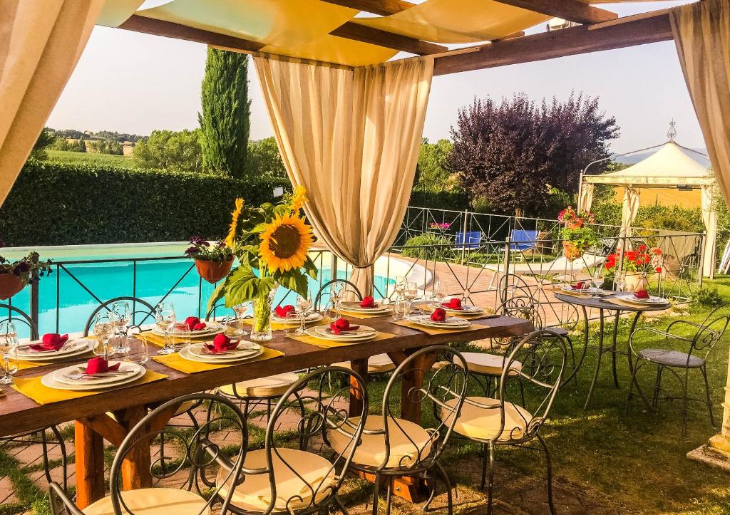 a table and chairs with a table and a pool at Il Poggio del Sole in Montefalco