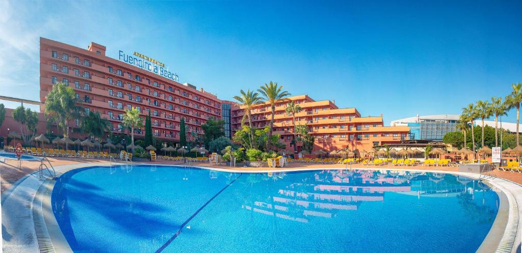 a large swimming pool in front of a hotel at Fuengirola Beach Apartamentos Turísticos in Fuengirola